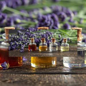 Assortment of essential oil bottles with cork tops on a wooden surface, set against a backdrop of vibrant lavender flowers, for the essential oils and diffusers page.